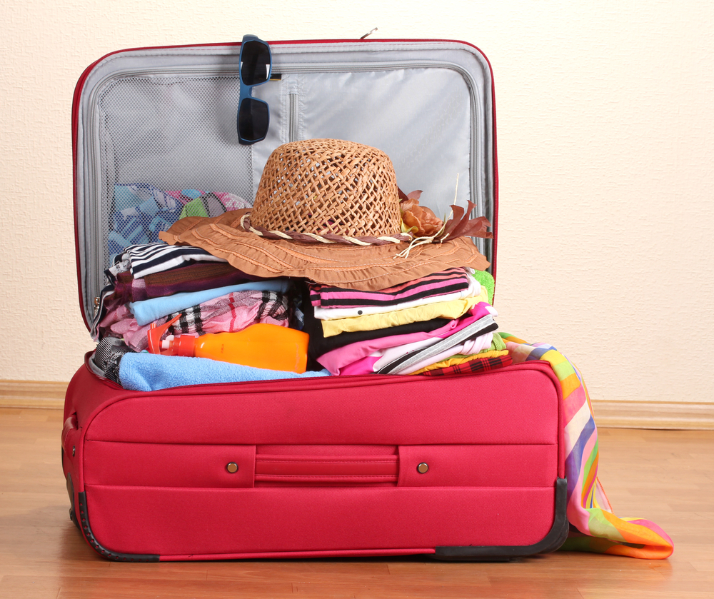 open-red-suitcase-with-clothing-in-the-room